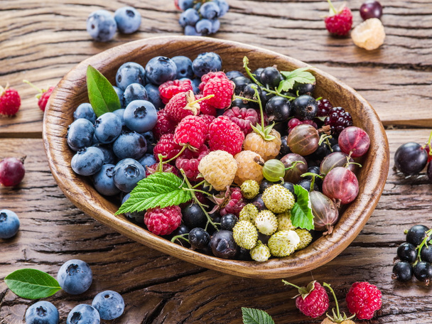 Ripe berries in the wooden bowl. - Valokuva, kuva