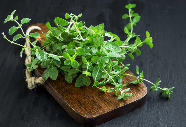Oregano aromatic herb bunch on wooden board - Photo, image