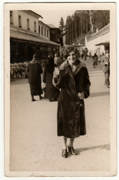 Vintage fotó azt mutatja, hogy nő visel bundát, megy sétálni retro fekete, fehér phortgraphy. - Fotó, kép