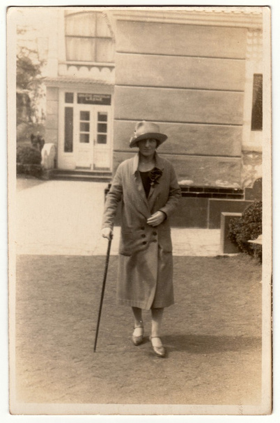 Vintage φωτογραφία δείχνει γυναίκα με ένα ραβδί στο θέρετρο σπα. Η γυναίκα πάει μια βόλτα. Ρετρό μαύρη & λευκή φωτογραφία. - Φωτογραφία, εικόνα