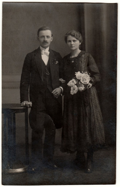 Ein altes Foto zeigt ein Paar in einem Fotostudio. Retro-Schwarz-Weiß-Fotografie mit Sepia-Effekt. - Foto, Bild