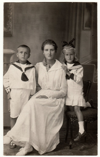 Vintage fotó azt mutatja, nő a gyerekeit (fiú és lány). Viselnek tengerész jelmezeket. Retro fekete reggeli fehér stúdió fotózás. - Fotó, kép