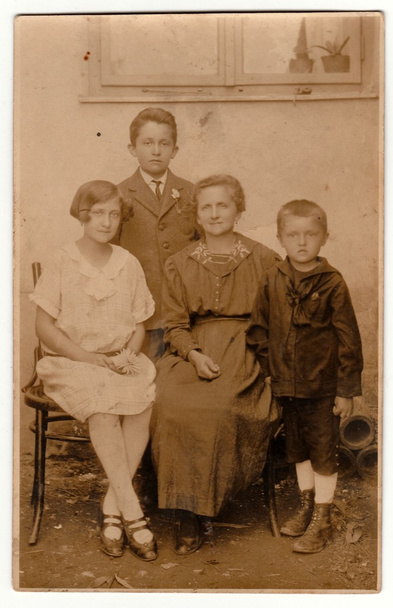  Ein altes Foto zeigt Motther und ihre Kinder, wie sie draußen posieren. Retro-Schwarz-Weiß-Fotografie mit Sepia-Effekt. - Foto, Bild