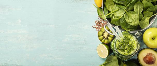 Healthy green smoothie and ingredients on blue background - Фото, зображення