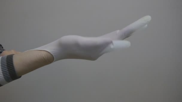 Beautician putting on rubber glove on her hand - Felvétel, videó