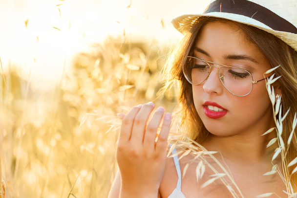 Chica adolescente tocando trigo en el campo
. - Foto, imagen