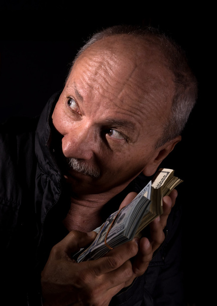 Сліпий старший чоловік тримає доларові купюри
 - Фото, зображення