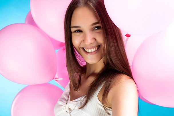 Gros plan de la jeune fille souriante prenant selfie dans des ballons à air
 - Photo, image