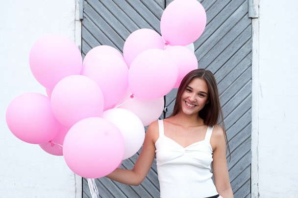 Pretty girl with pink balloons on wooden background - Foto, Imagen