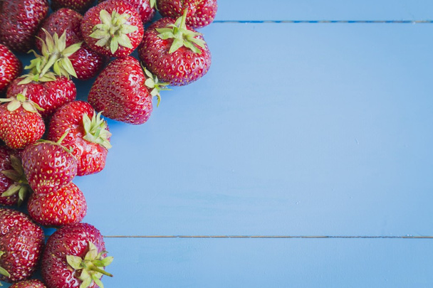 Fresh strawberries on blue background - Foto, afbeelding