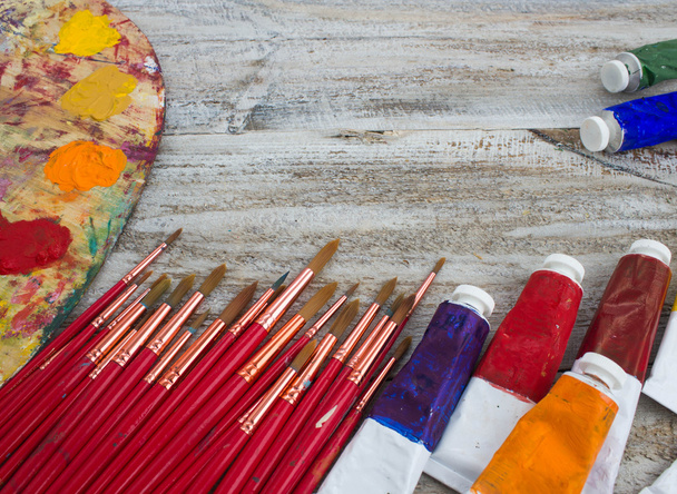 Brushes, paint, palette on wood background - Photo, Image