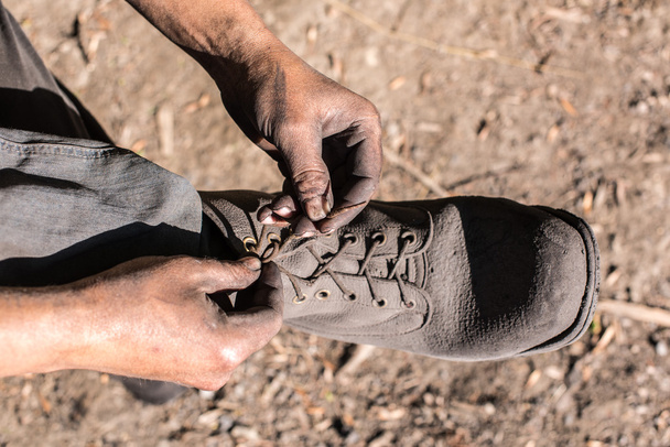 Worker man ties the shoelace. - Foto, imagen