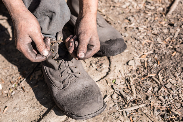 Worker man ties the shoelace. - Zdjęcie, obraz