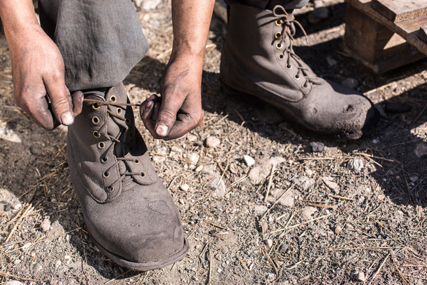 Worker man ties the shoelace. - Foto, Bild