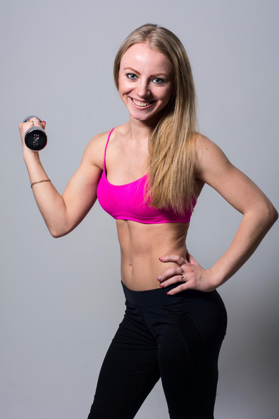 Portrait of smiling beautiful girl with dumbbells - Foto, immagini