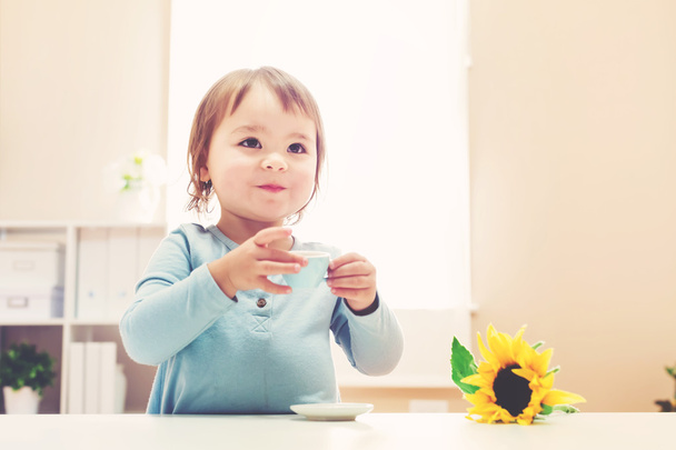 Happy toddler girl drinking from a teacup - Photo, Image