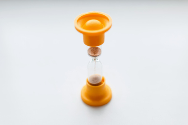 Vintage orange plastic hourglass on a white background. - Fotoğraf, Görsel