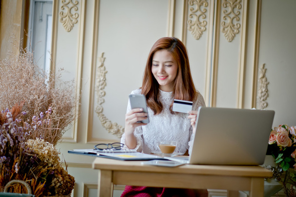 Foto de una joven hermosa comprando en línea y pagando con una tarjeta de crédito
.  - Foto, imagen