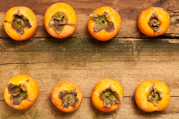 persimmon resting on an old table - Photo, Image