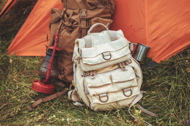 the tent and two backpacks near a tourist track in mountains on green grass - Foto, imagen