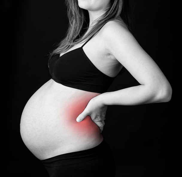 Ventre d'une femme enceinte souffrant de douleurs lombaires
. - Photo, image