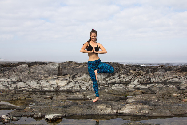 Femme relaxante en pratiquant le yoga près de la mer
 - Photo, image
