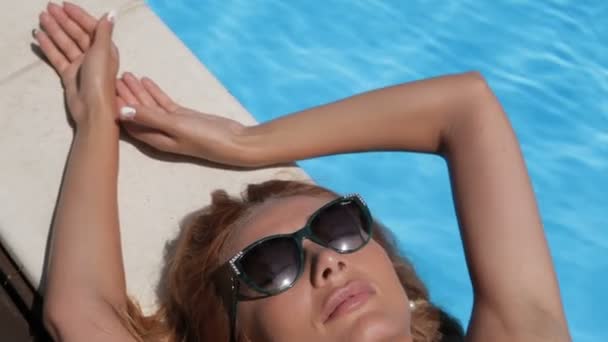 Woman relaxes on the pool edge - Felvétel, videó