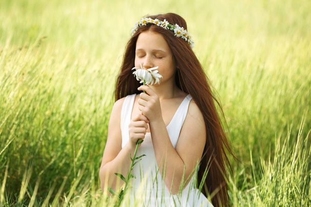 Sweet girl in meadow with chamomile flowers - Foto, immagini