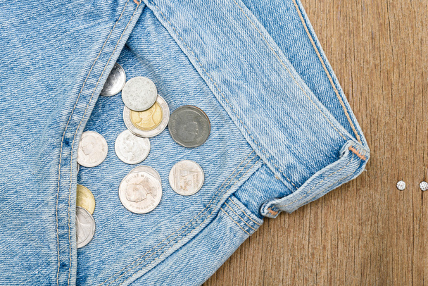 Ahşap arka plan üzerinde kot pantolon cebinden düşen paraları - Fotoğraf, Görsel
