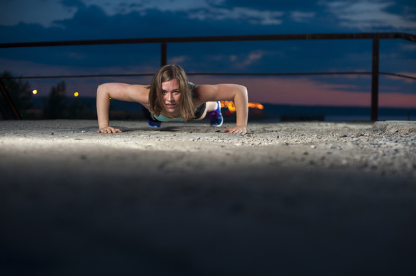 Portrait of strong fit woman doing push ups - Фото, изображение