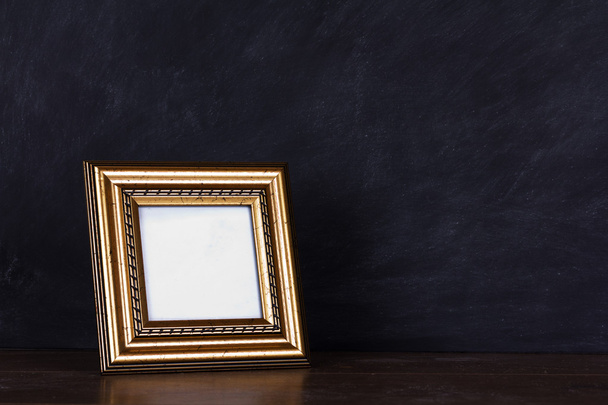 Picture frame against a dirty blackboard background - Photo, Image
