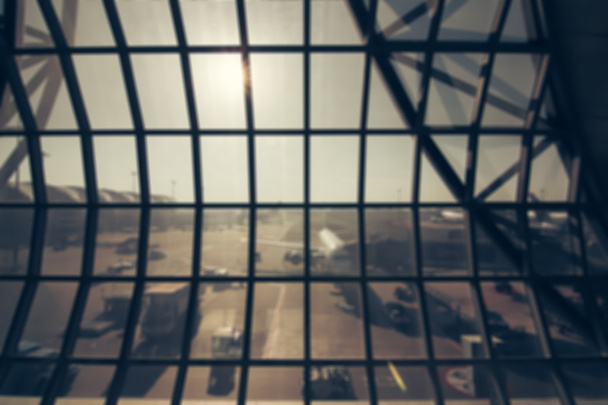 Розмитий фон: Пасажир чекає польоту в терміналі аеропорту розмитий фон з боке світлом
. - Фото, зображення