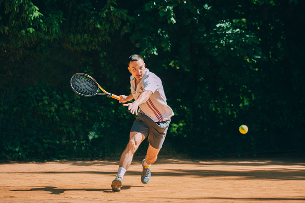 Male tennis player in action - Fotoğraf, Görsel