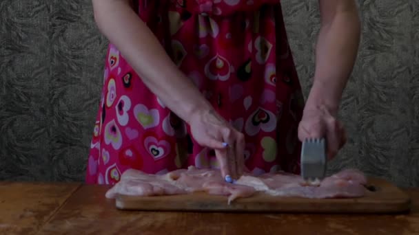 Dziewczyna w kuchni używa młotka mięsa specjalne. - Materiał filmowy, wideo