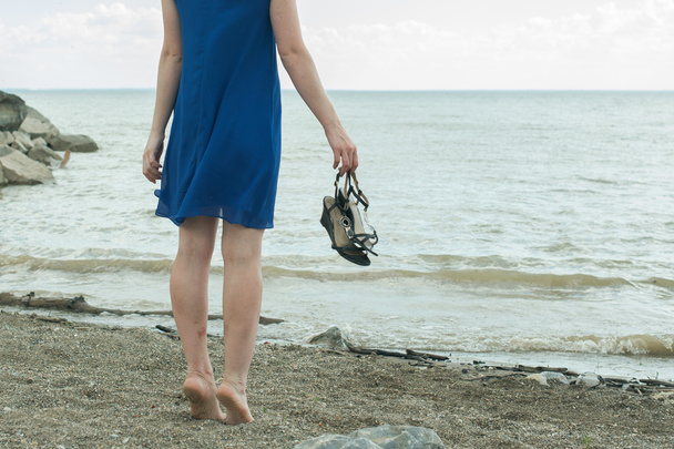 босиком девушка стоит на пляже и смотрит вдаль
 - Фото, изображение