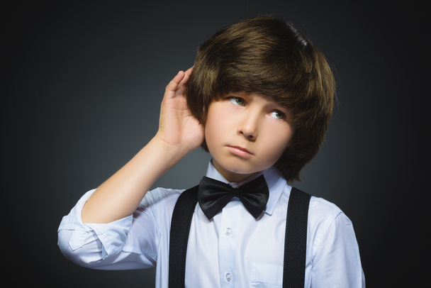 doubt, expression and people concept - boy thinking over gray background - Фото, изображение