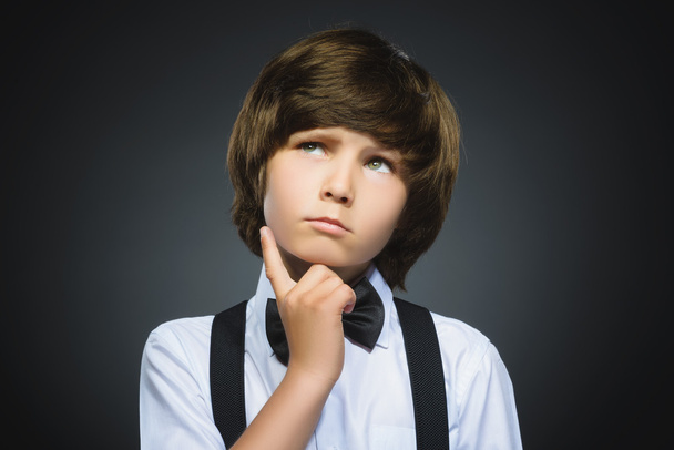 doubt, expression and people concept - boy thinking over gray background - Fotoğraf, Görsel