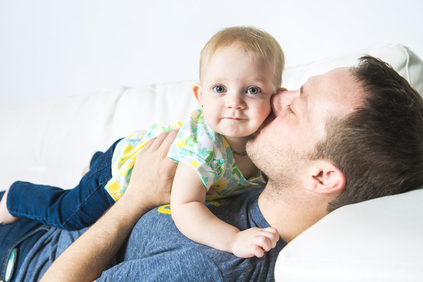 father with baby on the sofa taking good time - 写真・画像