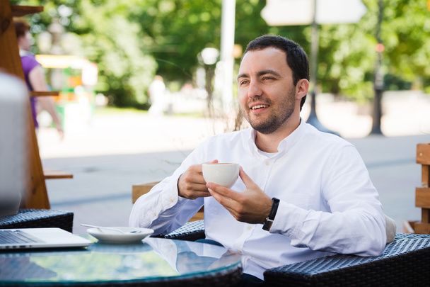Hombre de negocios exitoso y seguro en traje disfrutando de una taza de café mientras toma un almuerzo de descanso de trabajo en un restaurante moderno, joven hombre inteligente o empresario que se relaja en una cafetería al aire libre con aspecto pensativo
 - Foto, imagen
