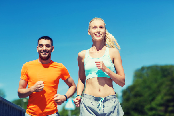 smiling couple running outdoors - Foto, afbeelding