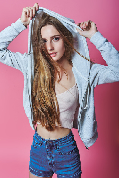 portrait of cheerful fashion hipster girl in casual colorful vivid hipster blue and pink summer clothes jeans on gray background covering her eyes with hands - Φωτογραφία, εικόνα