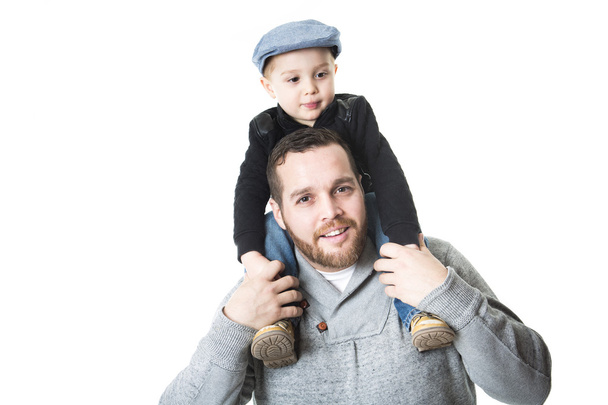 Father carrying his son on shoulders - isolated over a white background - Фото, изображение