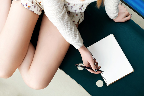 Girl's legs, writing in notebook - Photo, Image
