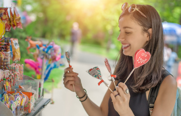 Smiling beautiful young woman with lollipops - Фото, изображение