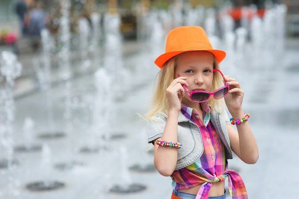 Маленька дівчинка виправляє сонцезахисні окуляри
 - Фото, зображення