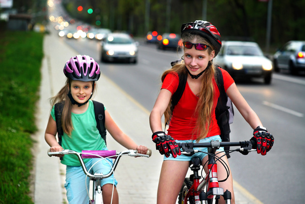 Děvčata děti na žluté cyklistické dráze. Automobily jsou silniční. - Fotografie, Obrázek