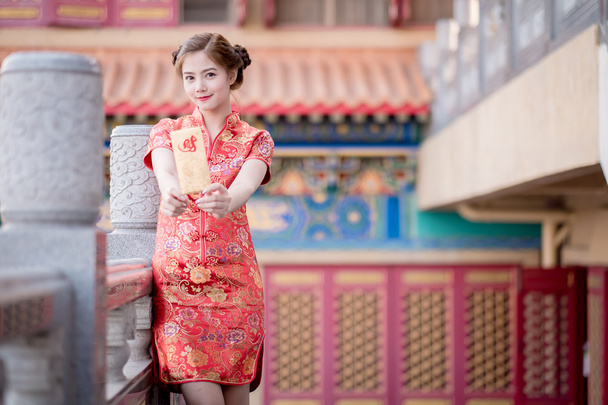 La mujer asiática en vestido chino celebración couplet 'Lucrativ
 - Foto, imagen