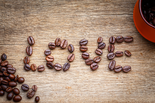 chicco di caffè amore Sul pavimento in legno
 - Foto, immagini