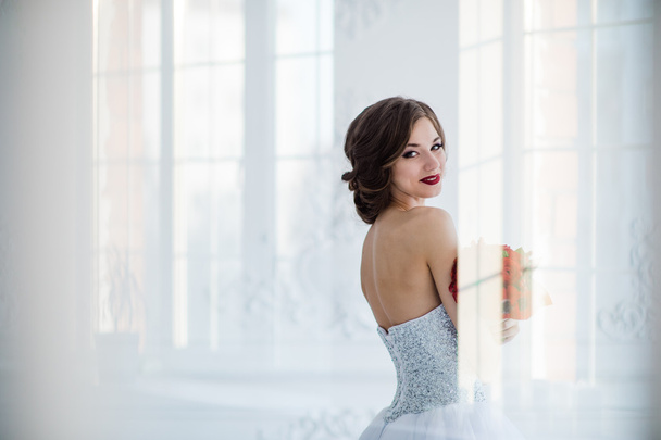 young and beautiful fashion art photo of a bride in white dress in living room. Shot through the glass of door, light creative reflections overlay portrait. - Φωτογραφία, εικόνα