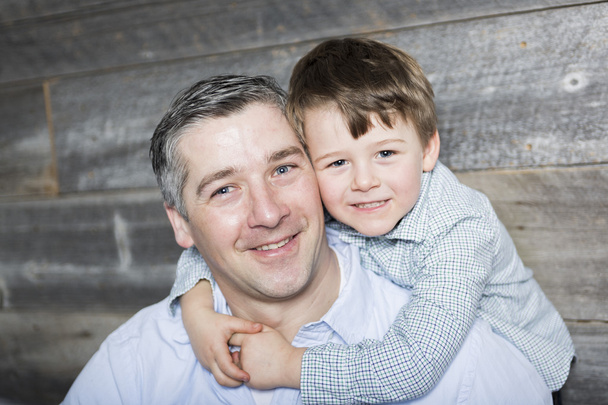 Young father with son in studio wood background - Фото, изображение
